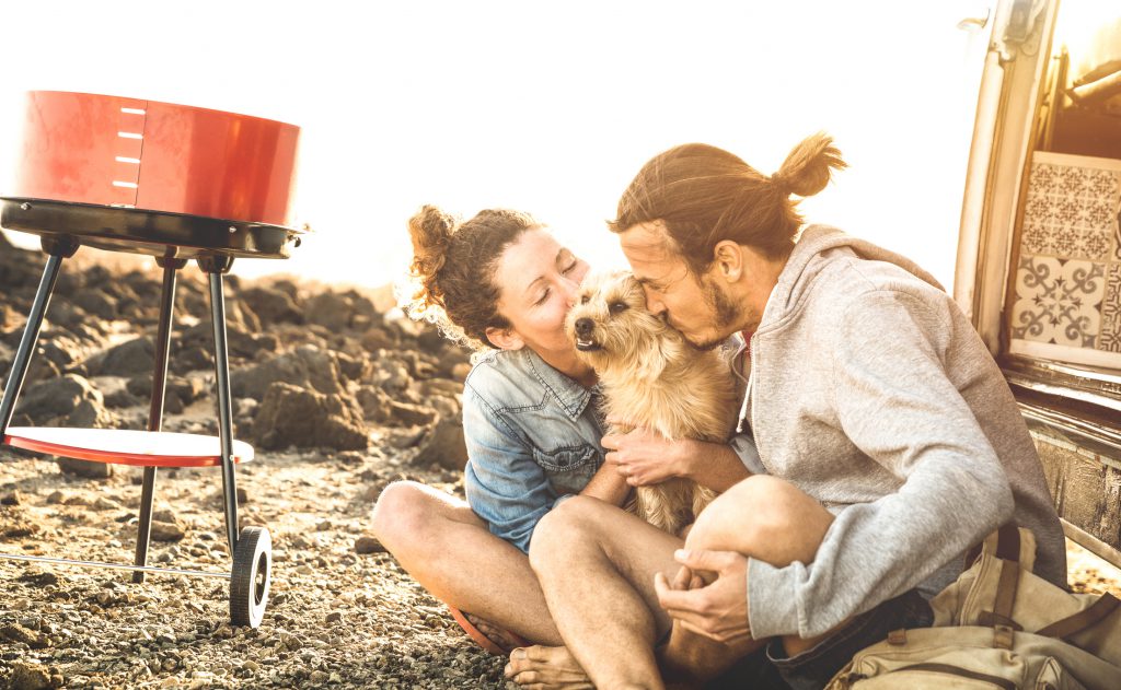 couple-kissing-dog-on-beach